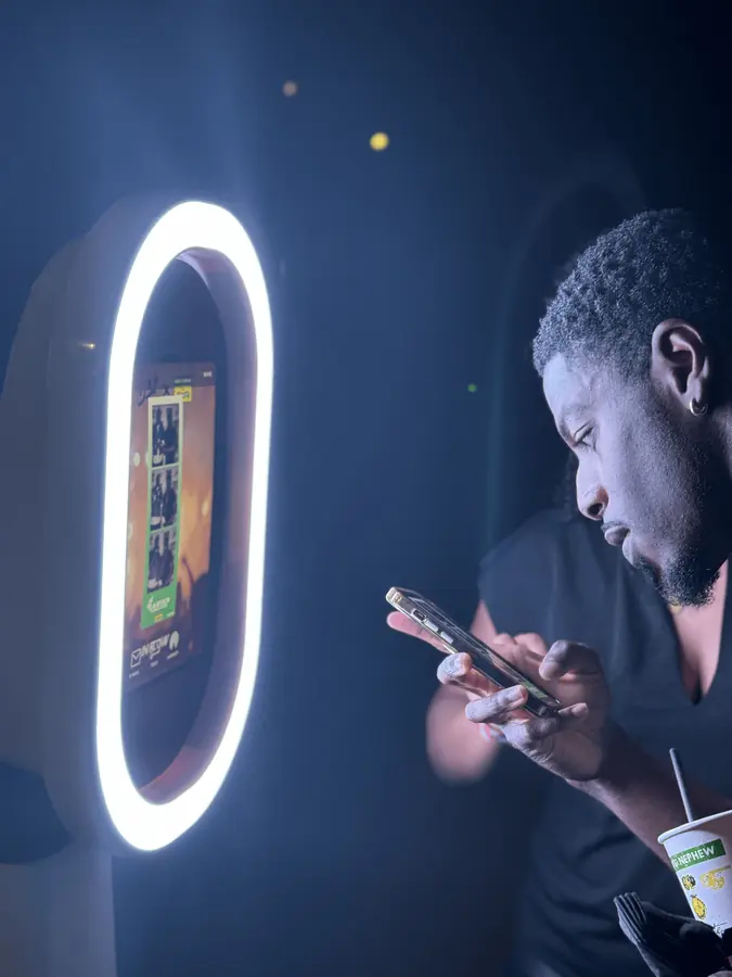 A guest checks his photos beside the glowing booth
