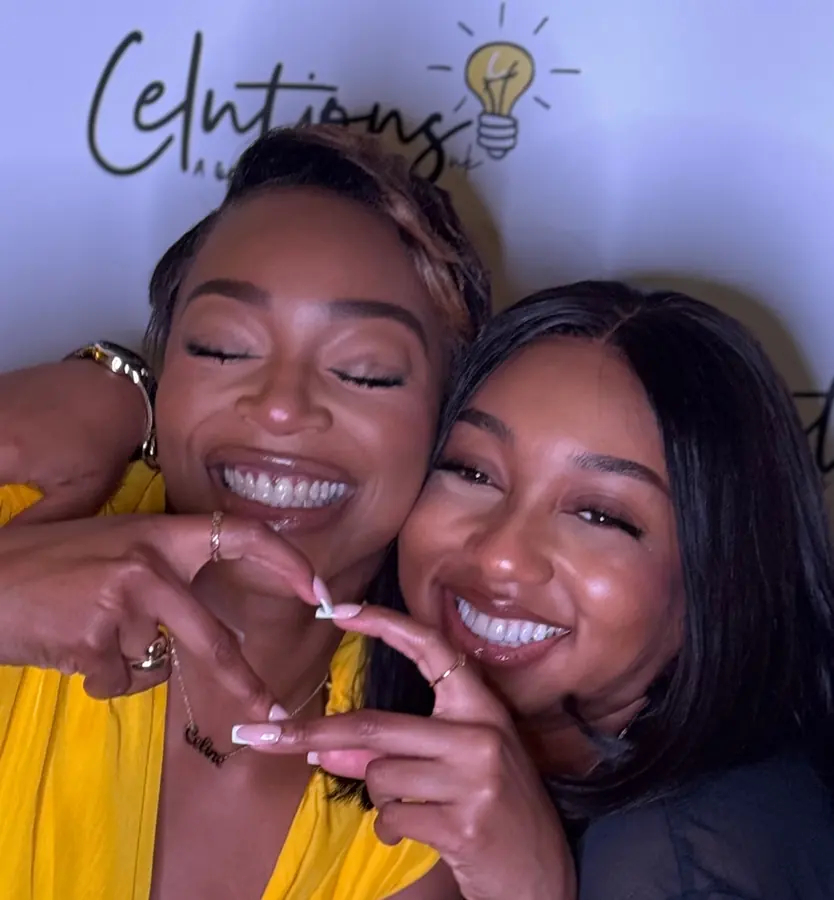 Two friends making a heart at a Celutions event