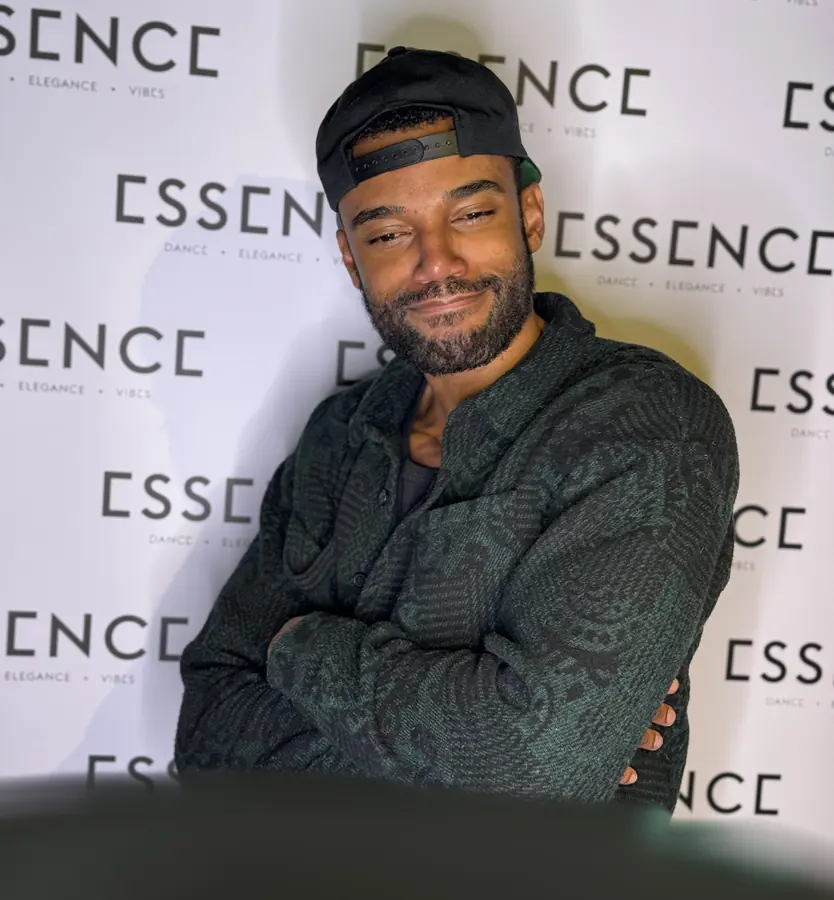 A guest smiling at the Essence backdrop