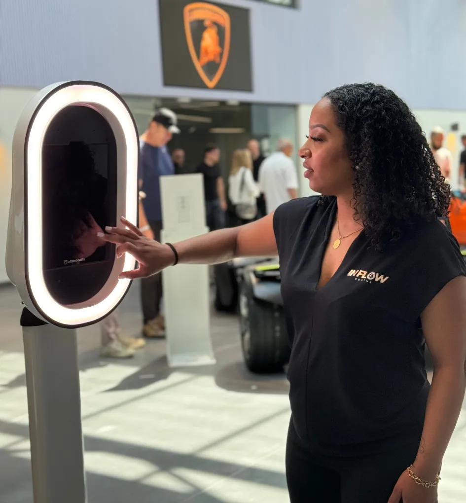 An In Flow host shows a guest the booth's touchscreen at a supercar showroom launch